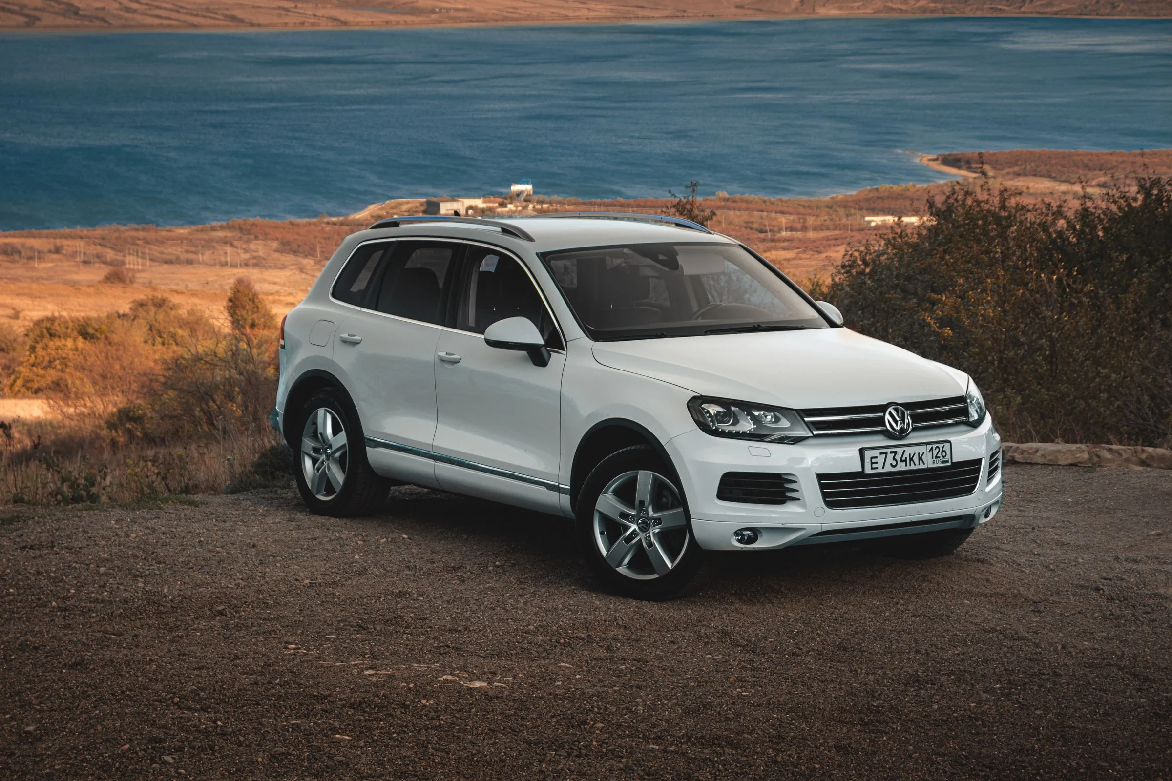 Weißes SUV vor einer weiten Landschaft – Symbolbild